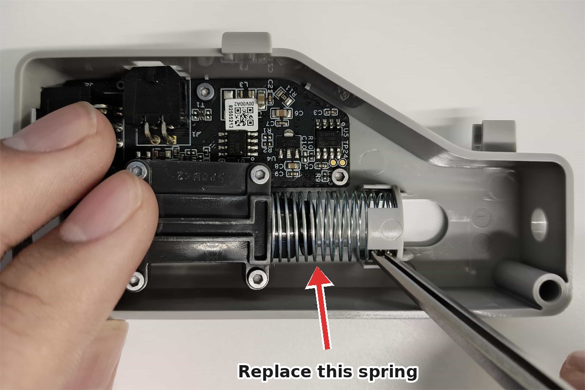 Inside the opened Bambu Lab filament buffer: the slider's coil spring, marked with a red arrow, is the spring to replace